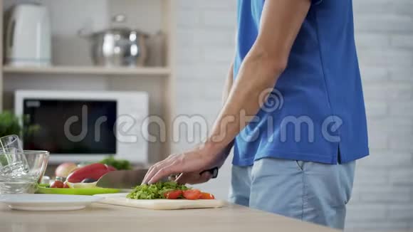 妻子轻轻地拥抱丈夫为家庭午餐做蔬菜沙拉视频的预览图