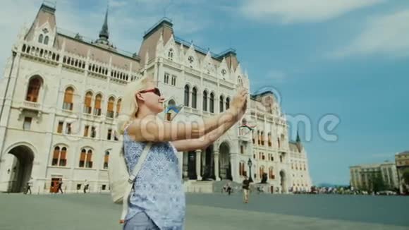 一位女游客在匈牙利议会背景下拍摄自己的照片欧洲旅游业视频的预览图