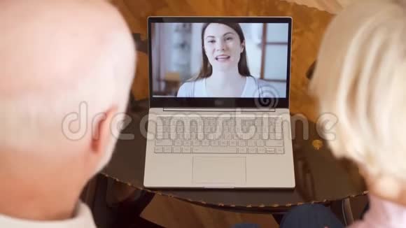 家中的老夫妻通过信使应用程序与女儿在国外的笔记本电脑进行视频聊天视频的预览图