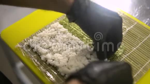 厨师的手准备日本菜厨师做寿司准备寿司卷把米饭放在底座上视频的预览图