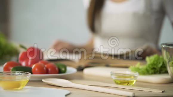 女孩翻阅烹饪书选择沙拉食谱的特写视频的预览图