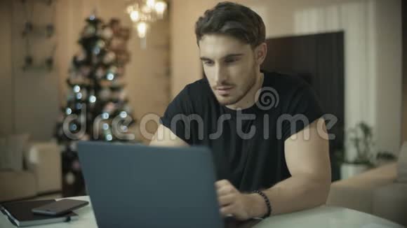 圣诞假期在家里使用笔记本电脑的男性在电脑上工作的人视频的预览图
