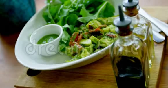 4k餐厅桌子上的一碗沙拉和橄榄油瓶视频的预览图