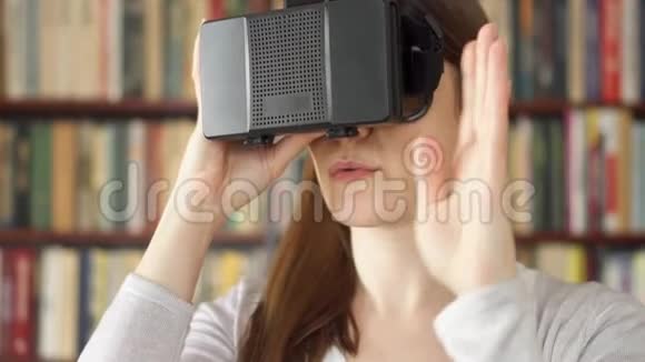 年轻女性在家使用VR360眼镜看到令人兴奋的东西用手做手势视频的预览图