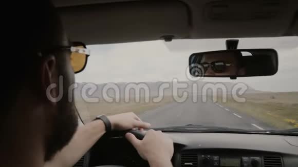 后景青年戴墨镜驾驶车辆另一男子坐在附近朋友一起坐车旅行视频的预览图