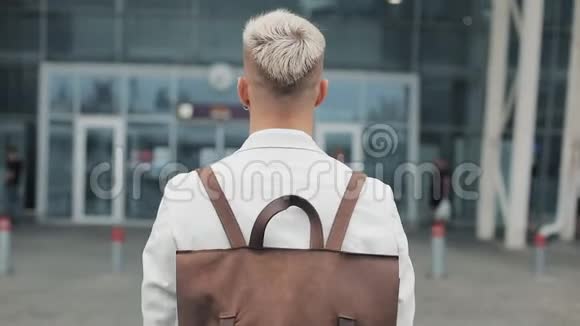 在工作的商人英俊的年轻人穿着白色衬衫带着背包去机场看着钟旅费视频的预览图