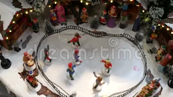 在冰冻冰场和背景是圣诞节市场上的迷你溜冰身影视频的预览图