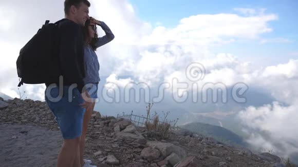 年轻的一对游客站在山顶看着美丽的风景向前他们男子和妇女视频的预览图