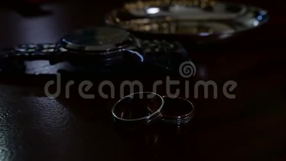 结婚戒指和桌上的男式手表视频的预览图