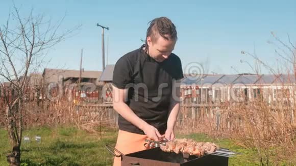 年轻人在后院的炭火烤架上烧肉视频的预览图