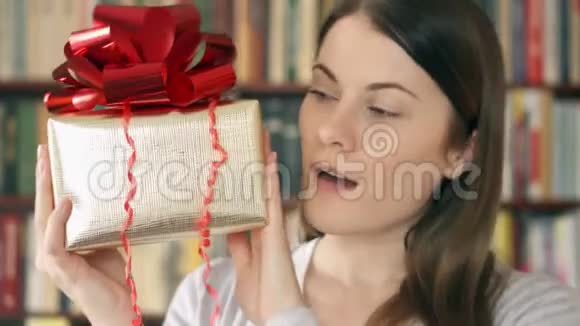 带礼物的年轻女人女性手持金色礼盒红色丝带庆祝生日视频的预览图