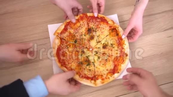 人手从打开的盒子里取出一片美味的意大利热比萨饼在宴会上提供送餐服务视频的预览图