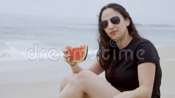 美丽的女人在海滩上吃西瓜视频的预览图