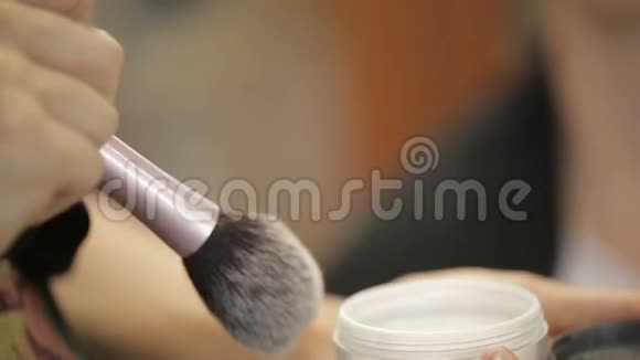 专业化妆师用刷子美容院在客户脸上涂红视频的预览图