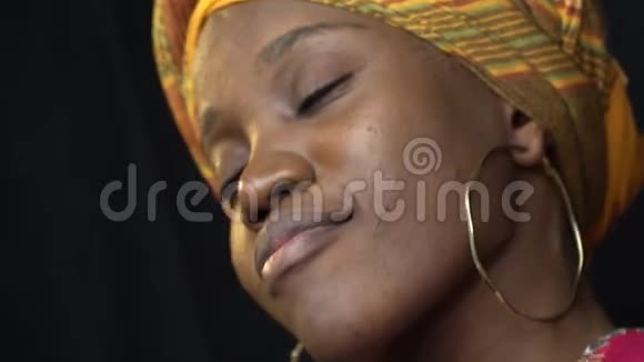 漂亮的非洲女人穿着国服耳朵上戴着金耳环在演播室里跳舞动作缓慢视频的预览图