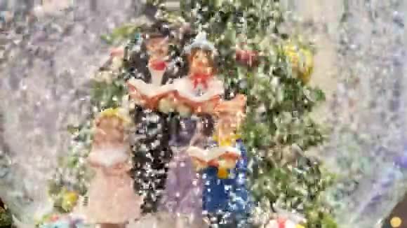 雪花中的圣诞玻璃球微型角色唱圣诞颂歌视频的预览图