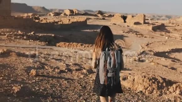 带背包的女人探索古老的沙漠废墟美丽的欧洲游客走在岩石和沙子上马萨达以色列4K视频的预览图