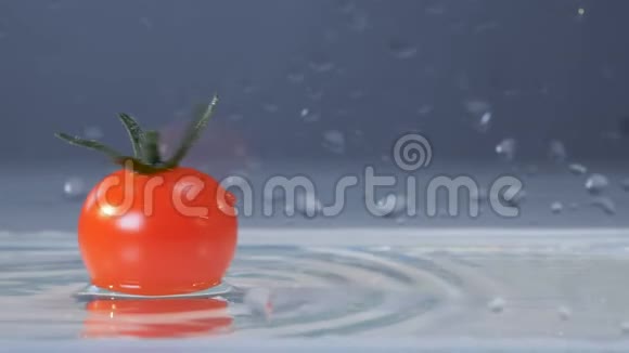 一种新鲜的番茄在水面上漂浮时绕着它的轴转视频的预览图