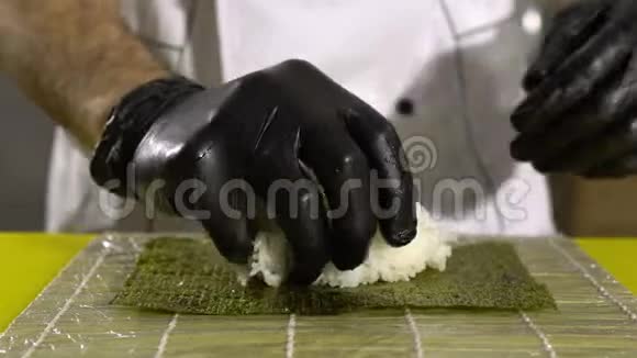 厨师的手准备日本菜厨师做寿司准备寿司卷把米饭放在底座上视频的预览图