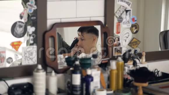 一个杂乱的理发师架子上有一面镜子显示沙龙的客户视频的预览图
