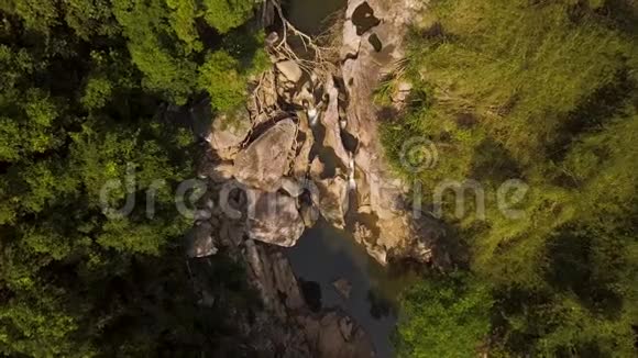 岩石河上的水流和绿色森林的空中镜头从飞行无人机可以看到清澈的河水视频的预览图