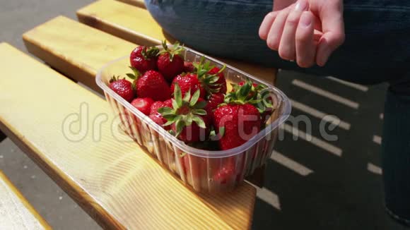 女人在阳光明媚的日子里展示她的有机草莓视频的预览图