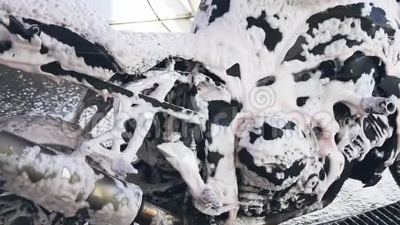 一个男人在洗车机上用泡沫清洗摩托车视频的预览图
