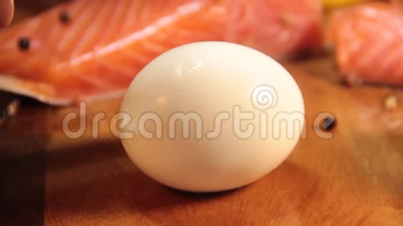 鸡蛋是用刀子切在木头红鱼上的视频的预览图