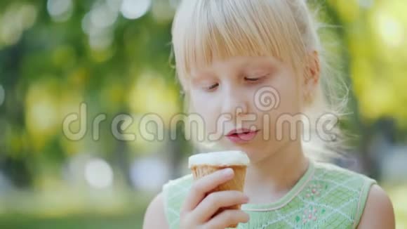 体贴的女孩6岁正在公园里吃冰淇淋暑假和假期视频的预览图