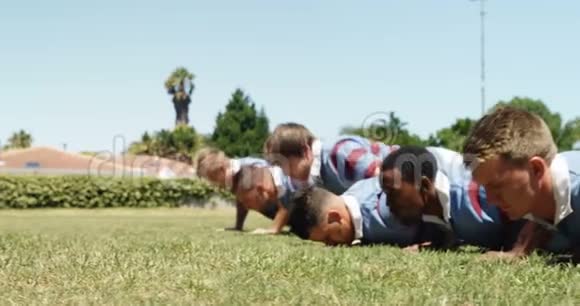 橄榄球队员在球场上做俯卧撑视频的预览图