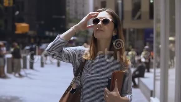 年轻漂亮的女商人拿着文件在市中心的咖啡休息时间散步的肖像慢动作视频的预览图