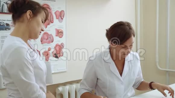 一位女医生给一位生病的医生看一张医疗图表视频的预览图