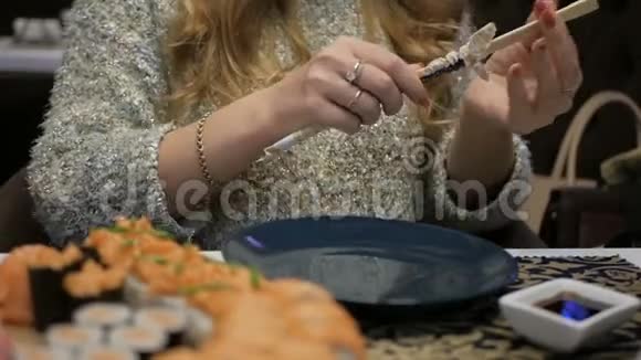 日本料理的概念餐馆里的女孩吃寿司和卷视频的预览图