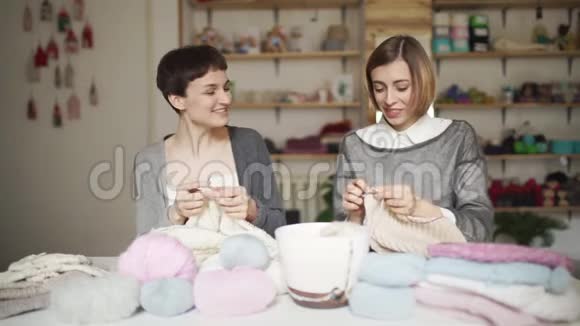 两个快乐的女朋友在家里的工作室玩毛线衣视频的预览图