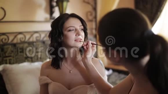 专业化妆师在房间里化妆漂亮的女孩视频的预览图