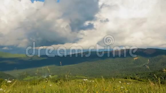 美丽的蓬松的云彩在高高的山峦上的蓝天上奔跑时间流逝视频的预览图