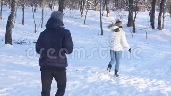 可爱的年轻夫妇在冬天的森林里奔跑视频的预览图