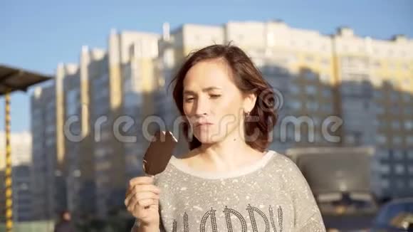 一个深色的女人正在吃冰淇淋上面有巧克力糖霜视频的预览图