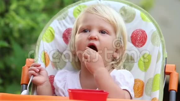 小女孩坐在椅子上吃芒果微笑视频的预览图