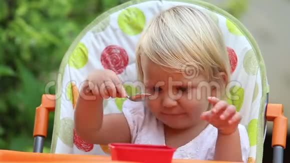 小女孩坐在椅子上吃芒果和笑视频的预览图