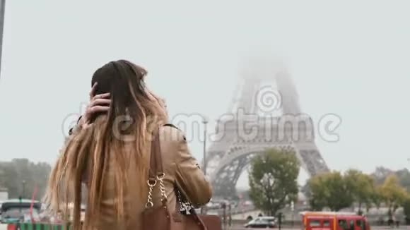 年轻快乐的女人在法国巴黎市中心散步用手机交谈在埃菲尔铁塔附近微笑的女性视频的预览图