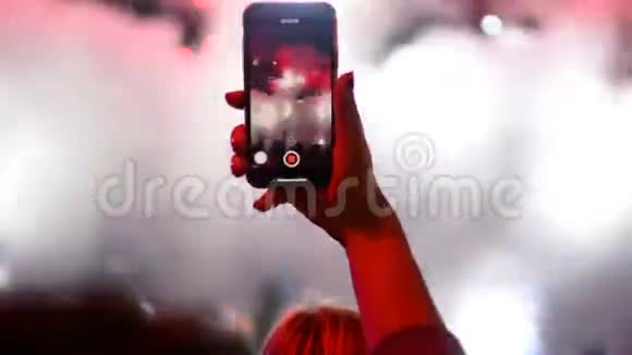 在舞台上的摇滚乐队音乐演奏会上用手机和手机拍照视频的预览图