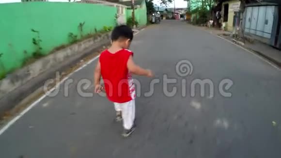 小男孩学着独自走在沥青路面上视频的预览图