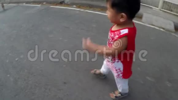 小男孩学着独自走在沥青路面上视频的预览图