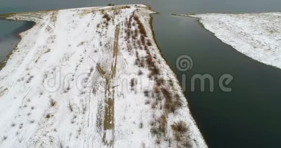雪覆盖了河边的土地和山脉视频的预览图