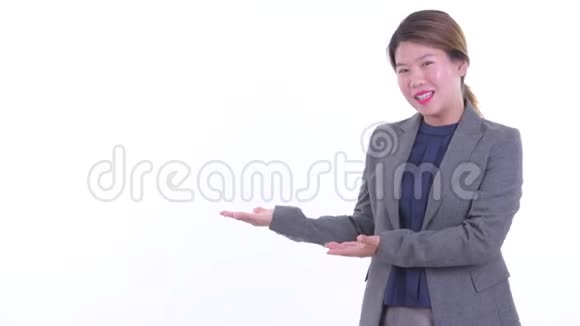快乐的年轻亚洲女商人一边说话一边展示视频的预览图