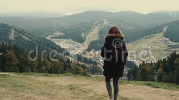镜头跟随年轻女孩徒步旅行者在山上行走举起手臂飞向空中视频的预览图