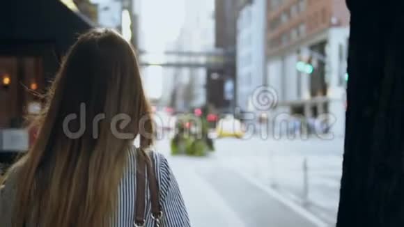从美国纽约街头走过的年轻黑发女人的后景头发随风飘扬慢动作视频的预览图