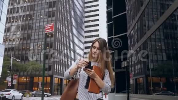 年轻的女商人穿过美国纽约金融区用手机交谈慢动作视频的预览图