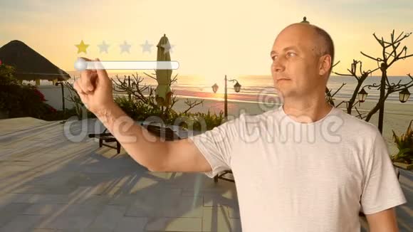 日落时一个站在海滩附近的人给度假村评5颗星虚拟屏幕手指男人的手视频的预览图
